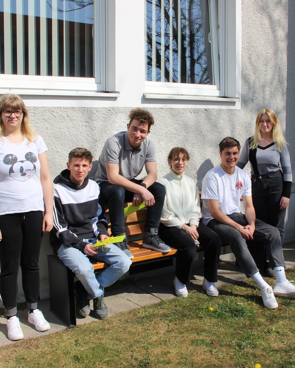drei Mädchen und drei Jungen, die auf einer sonnigen Bank sitzen | © RÖSLE GROUP
