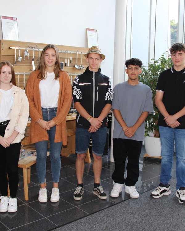Ausbildungsstart 2022 | © RÖSLE GROUP zwei Mädchen und drei Jungen stehen vor der Produktausstellung im Eingangsbereich des RÖSLE-Gebäudes | © RÖSLE GROUP