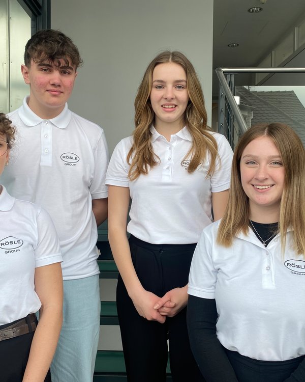 Drei Mädchen und ein Junge stehen in den RÖSLE GROUP Poloshirts auf einer Treppe | © RÖSLE GROUP
