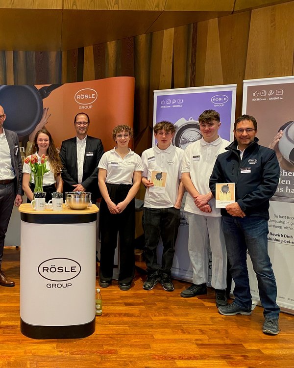Fünf Männer und zwei Frauen die an einem Messestand stehen vor ihnen ein kleiner Tisch mit Blumen hinter ihnen Banner mit Ausbildungswerbung | © RÖSLE GROUP Fünf Männer und zwei Frauen die an einem Messestand stehen vor ihnen ein kleiner Tisch mit Blumen hinter ihnen Banner mit Ausbildungswerbung | © RÖSLE GROUP