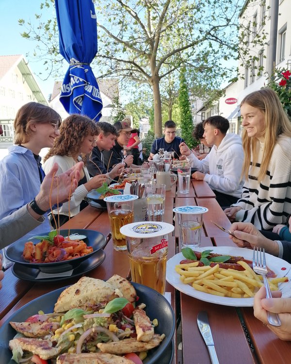 Firmenrallye 2023 | © RÖSLE GROUP Eine Gruppe, die im Außenbereich eines Restaurants gemeinsam Mittag isst | © RÖSLE GROUP