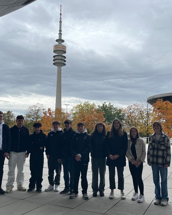 Azubi-Ausflug BMW-Museum | © RÖSLE GROUP vier Mädchen und sechs Jungen stehen vor dem BMW-Museum, im Hintergrund ist der Olympiaturm zu sehen | © RÖSLE GROUP